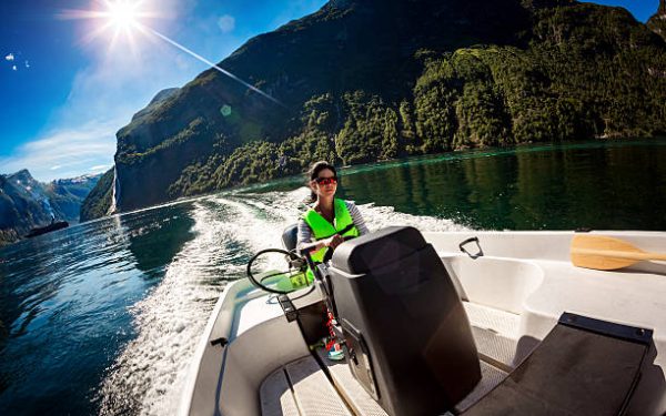 bateau 6 Woman driving a motor boat. Geiranger fjord, Beautiful Nature Norway.Summer vacation.