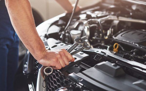 Mécanique auto Picture showing muscular car service worker repairing vehicle.